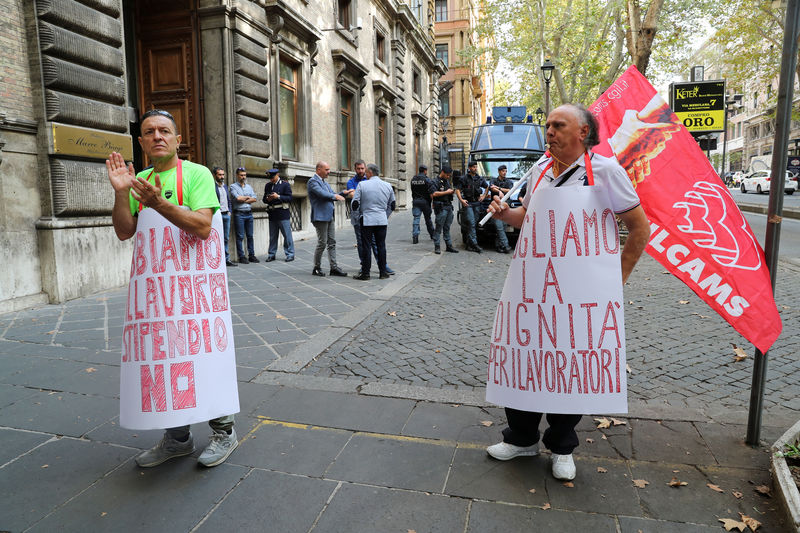 © Reuters. People wearing signs protest in front of the Italian Ministry of Labour office in Rome