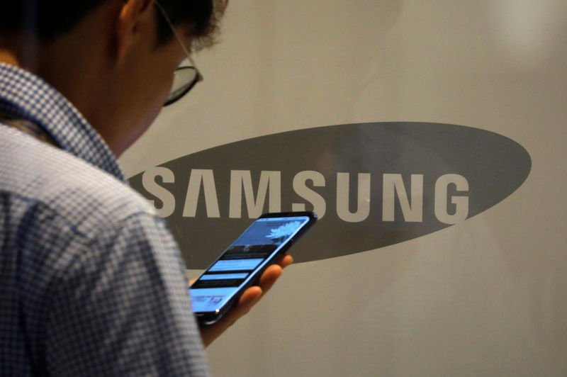 © Reuters. Pessoa utiliza celular diante de logo da Samsung em Seul, Coreia do Sul