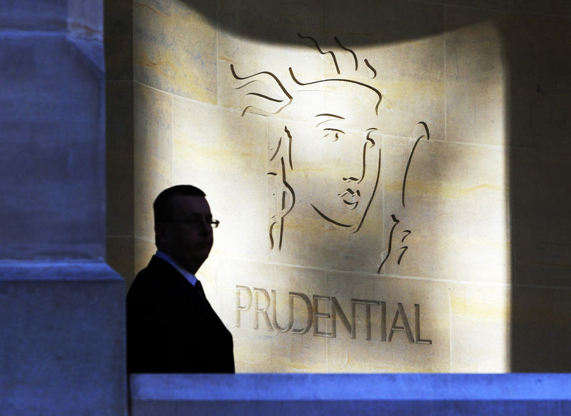 © Reuters. A security guard is silhouetted in front a Prudential office in London