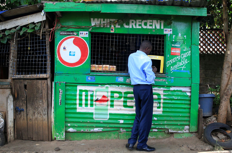 © Reuters. Customer conducts a mobile money transfer at a Safaricom agent stall in Nairobi