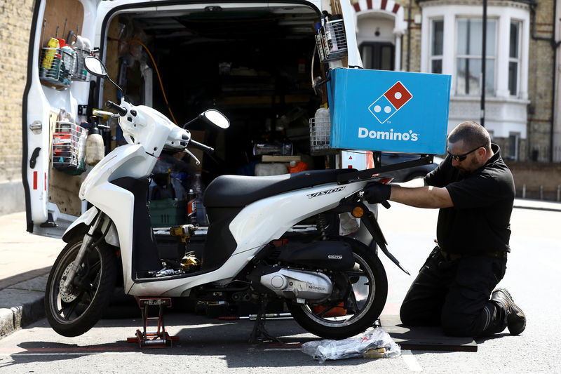 © Reuters. A call out mechanic fixes a Dominos delivery scooter in the Clapham district of London