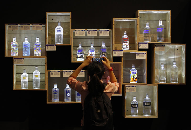 © Reuters. A visitor takes photos of limited edition Absolut Vodka bottles at the 
