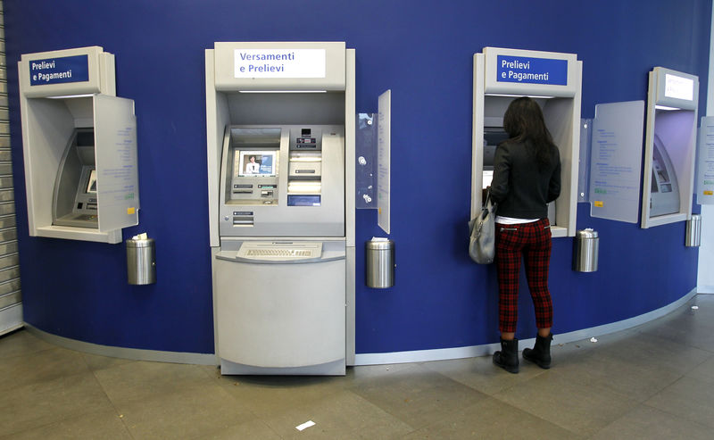 © Reuters. A woman gets money at an ATM machine in Milan
