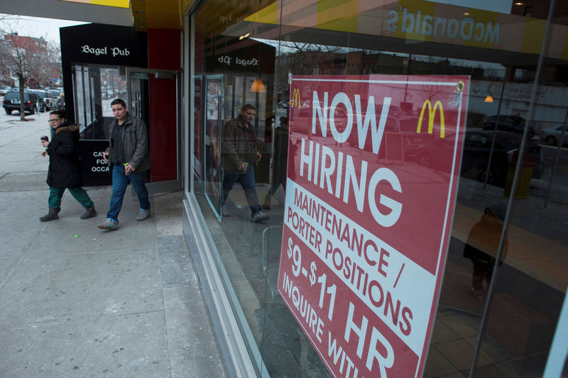 © Reuters. FILE PHOTO: Passersby walk in front of a help wanted sign at a McDonalds restaurant in the Brooklyn borough of New York