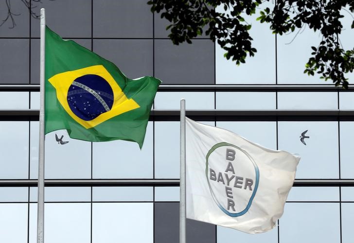 © Reuters. The Brazilian national flag is seen next to Bayer's flag in front of Bayer headquarters in Sao Paulo