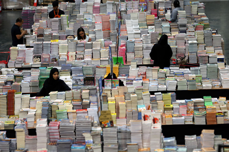 © Reuters. Visitantes leem livros durante feira literária Big Bad Wolf em Dubai, nos Emirados Árabes Unidos