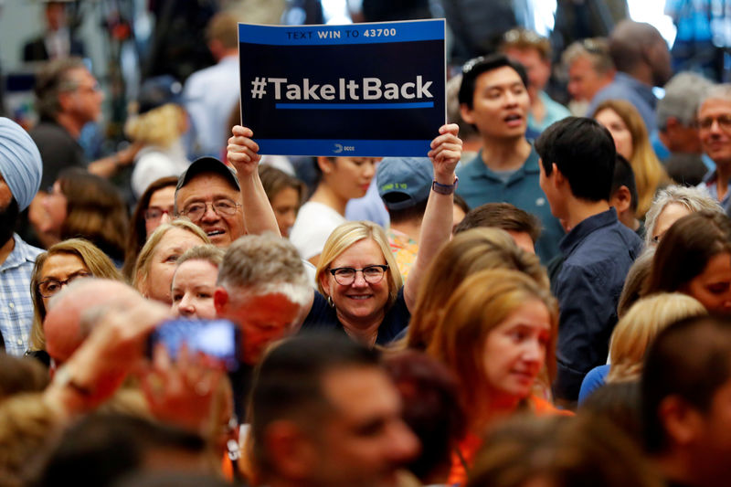 © Reuters. FILE PHOTO: A woman in the crowd holds up a "Take It Back" sign as she attends a political rally with former U.S. President Barack Obama for California Democratic candidates in Anaheim
