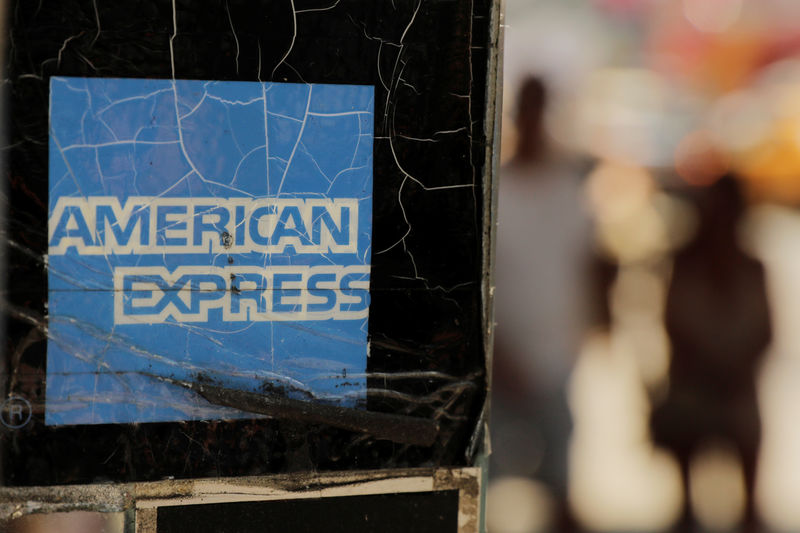 © Reuters. FILE PHOTO: Pedestrians walk past an American Express sign in New York
