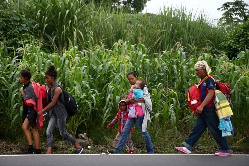 © Reuters. Honduran migrants, part of a caravan trying to reach the U.S., walk during a new leg of their travel in Siquinala