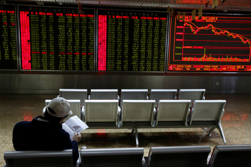 © Reuters. An investor sits in front of displays showing stock information at a brokerage office in Beijing