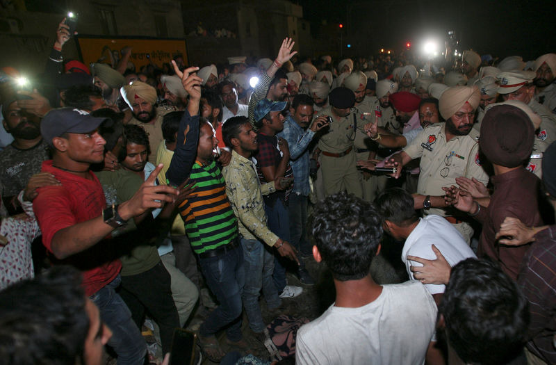 © Reuters. Pessoas e policiais após acidente envolvendo trem em Amritsar, na Índia