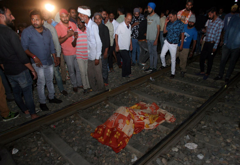 © Reuters. Pessoas cercam corpo de vítima de acidente com trem em Amritsar