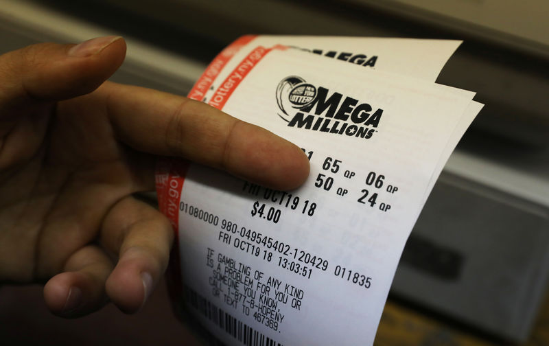 © Reuters. Un cliente sostiene boletos de la lotería Mega Millions en un puesto de periódicos en Manhattan