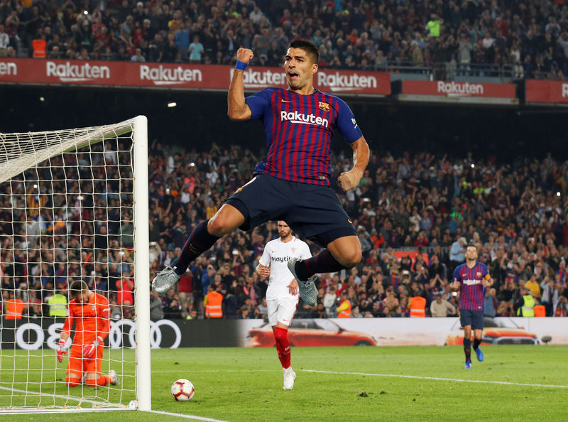 © Reuters. El delantero uruguayo Luis Suárez celebra tras anotar un gol de penal en el partido contra el Sevilla por la Liga Española, en Barcelona