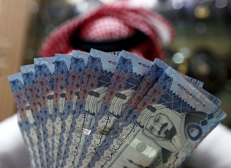 © Reuters. FILE PHOTO: Saudi money changer displays Saudi Riyal banknotes at a currency exchange shop in Riyadh