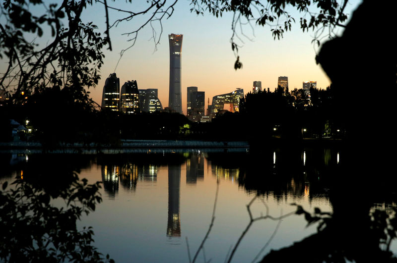© Reuters. The cityscape of the Beijing Central Business District is reflected in a pond during sunset