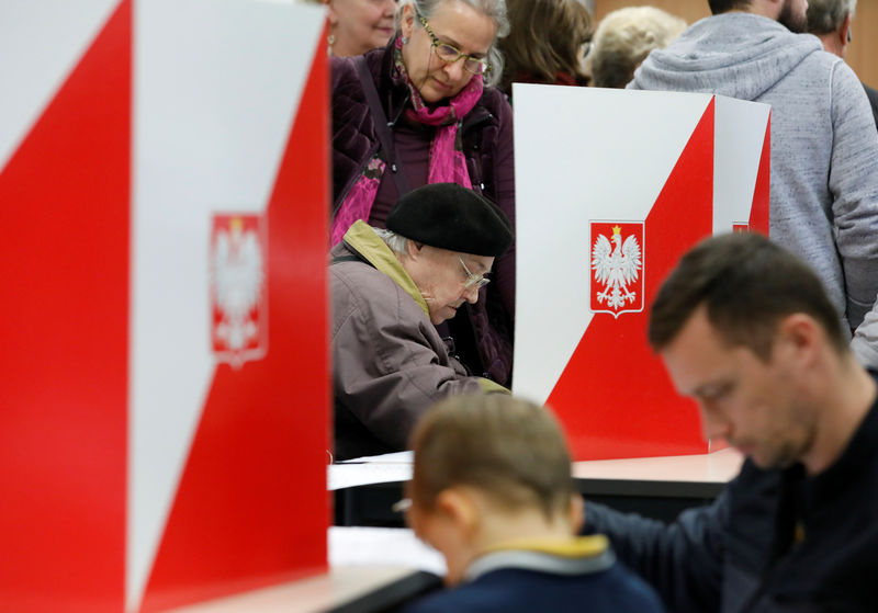 © Reuters. People attend the Polish regional elections, at a polling station in Warsaw