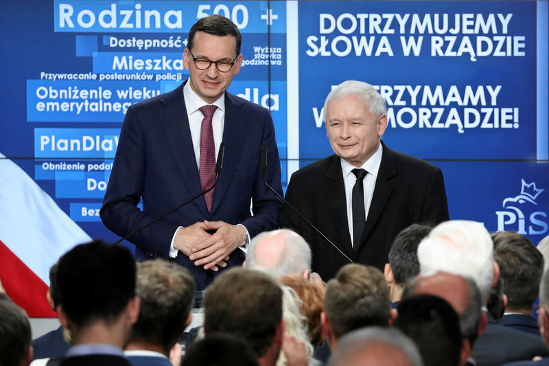 © Reuters. Polish Prime Minister Morawiecki and Kaczynski react after the exit poll with results of the Polish regional elections are announced in Warsaw
