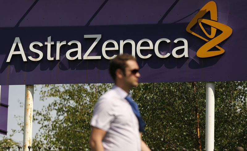 © Reuters. FILE PHOTO - A man walks past a sign at an AstraZeneca site in Macclesfield