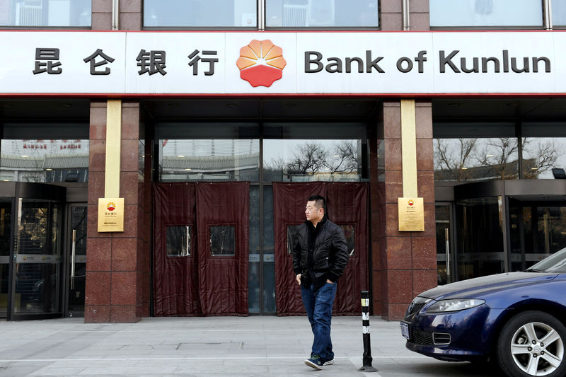 © Reuters. Man walks past a Bank of Kunlun branch in Beijing