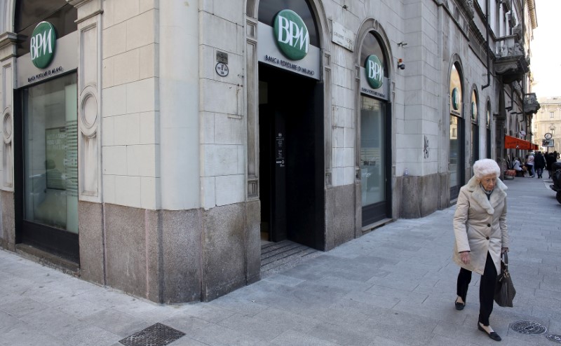 © Reuters. A woman walks past Banca Popolare di Milano ( BPM) downtown Milan