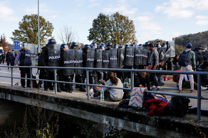 © Reuters. Polícia croata forma cordão de isolamento em frente a migrantes na passagem da fronteira de Maljevac, entre a Bósnia e a Croácia