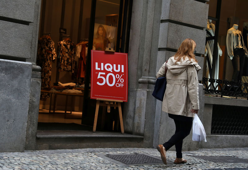 © Reuters. Mulher passa por vitrine de loja de roupas no centro do Rio de Janeiro