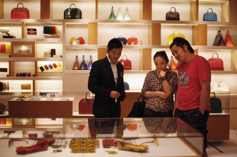 © Reuters. FILE PHOTO: A couple shop at a Louis Vuitton store during Vogue's 4th Fashion's Night Out: Shopping Night with Celebrities in downtown Shanghai