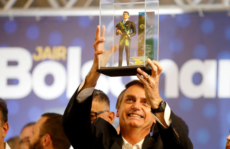 © Reuters. FILE PHOTO: Federal deputy Jair Bolsonaro, a candidate for Brazil's presidential elections, shows a doll of himself during a rally in Curitiba