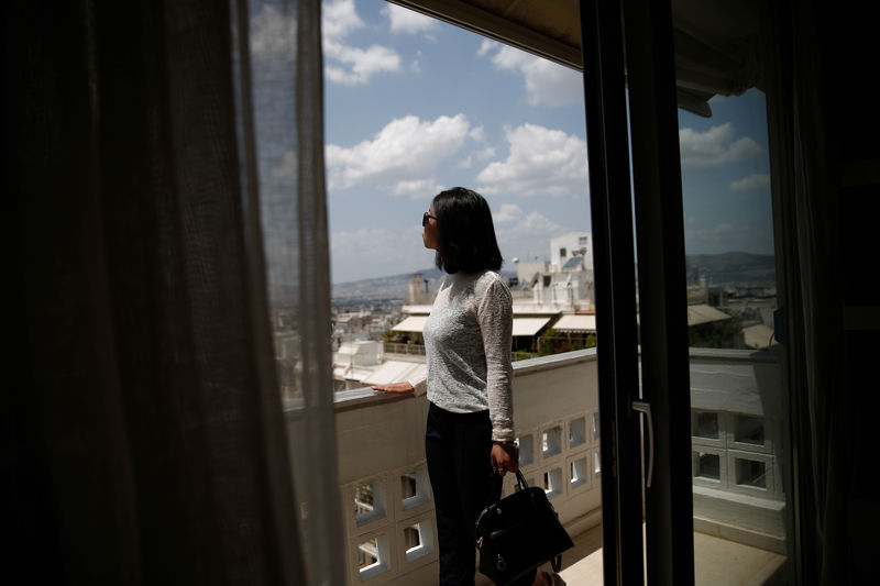 © Reuters. Lian Wenmin, 29, potential buyer from China looks out from the balcony of an apartment in central Athens