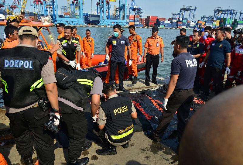 © Reuters. Rescue team members stand beside body bags with the remains of passengers of Lion Air, flight JT610, that crashed into the sea, at the Tanjung Priok port in Jakarta