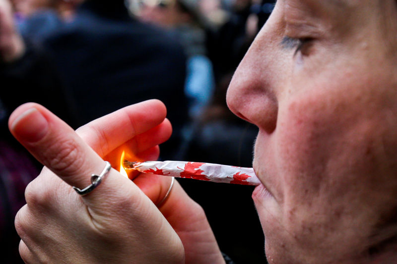 © Reuters. FILE PHOTO: A woman smokes a joint on the day Canada legalized recreational marijuana