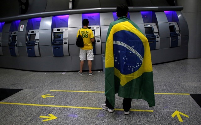 © Reuters. Pessoas sacam dinheiro em caixa eletrônico de banco em São Paulo
