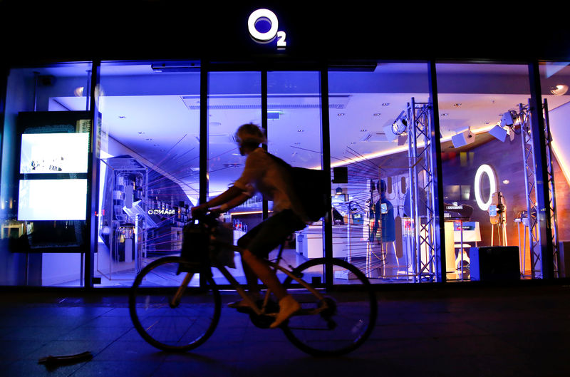 © Reuters. A cyclist passes the front of a O2 Deutschland shop in Berlin