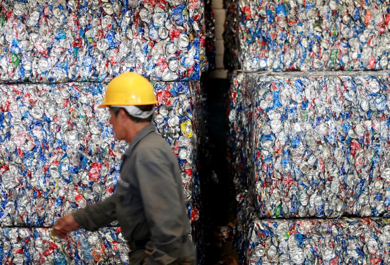 © Reuters. FILE PHOTO: A worker walks in front of compacted cans in an aluminium recycling plant in Ciudad Juarez