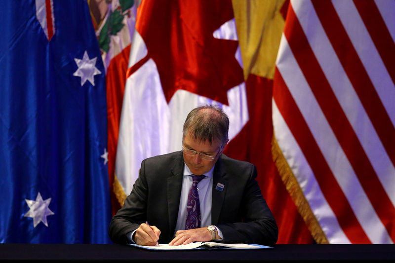 © Reuters. New Zealand's Minister for Trade and Export Growth David Parker signs the Trans-Pacific Partnership (TPP) trade deal, in Santiago