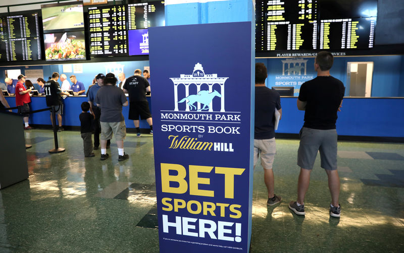 © Reuters. FILE PHOTO: Gamblers place bets on sports at Monmouth Park Sports Book by William Hill, shortly after the opening of the first day of legal betting on sports in Oceanport