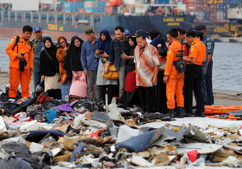 © Reuters. Familiares de passageiros de voo da Lion Air que caiu no mar observam pertences de passageiros do avião no porto de Jacarta