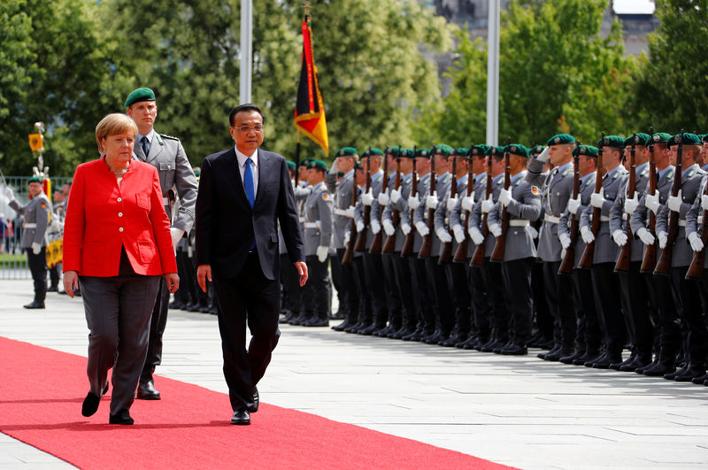 © Reuters. FILE PHOTO: German Chancellor Angela Merkel and Chinese Prime Minister Li Keqiang review the guard of honour at the chancellery in Berlin