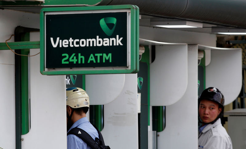 © Reuters. Men withdraw money from an ATM at a branch of Vietcombank in Hanoi