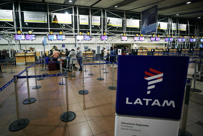 © Reuters. FILE PHOTO: Passengers wait to check in for their flights at the departures area of Latam airlines inside the international airport in Santiago