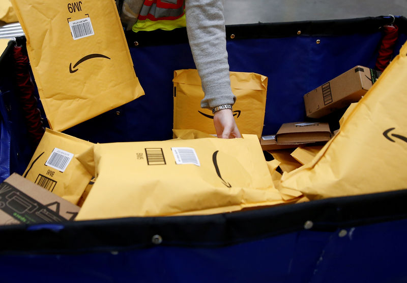 © Reuters. FILE PHOTO: Area manager Wells retrieves packages to put them on a conveyor line for scanning and labeling at the Amazon fulfillment center in Kent