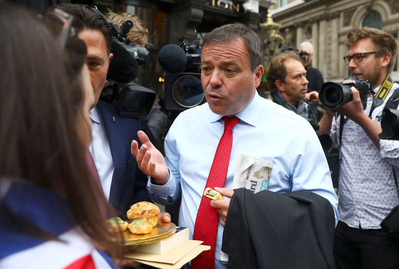 © Reuters. FILE PHOTO:  Arron Banks and Andy Wigmore, who ran the Leave.Eu pro-Brexit referendum campaign, eat pork pies offered by an anti-Brexit campaigner as they arrive to give evidence to the Digital Culture Media and Sport Parliamentary Committee in London