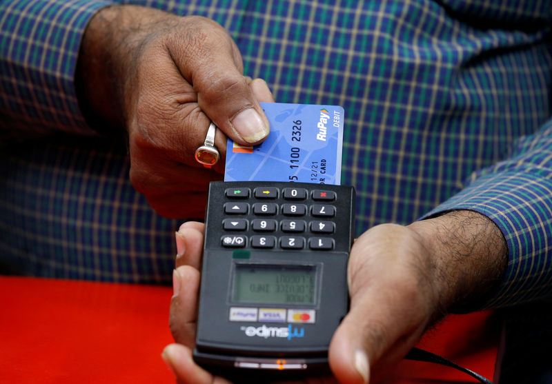 © Reuters. A shopkeeper swipes a customer's debit card with the logo of RuPay at an electronics goods store in Kolkata