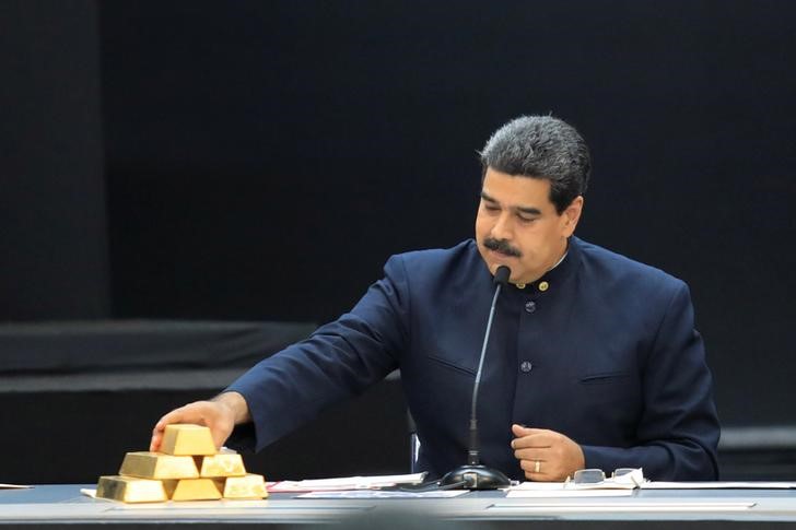 © Reuters. FILE PHOTO - Venezuela's President Maduro touches a gold bar as he speaks during a meeting with the ministers responsible for the economic sector in Caracas