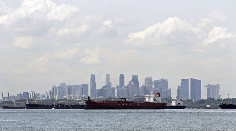 © Reuters. FILE PHOTO - Oil tankers are pictured against the skyline of the CBD in Singapore