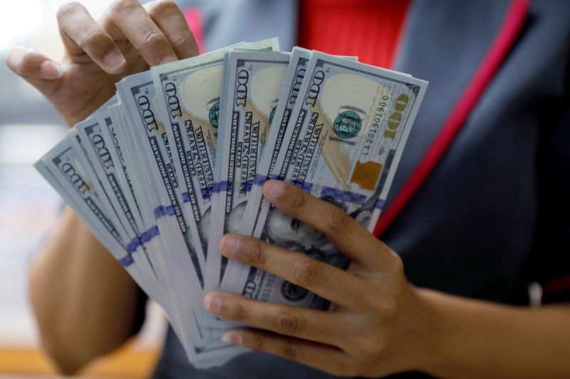 © Reuters. FILE PHOTO - An employee counts U.S. dollar banknotes at a currency exchange office in Jakarta
