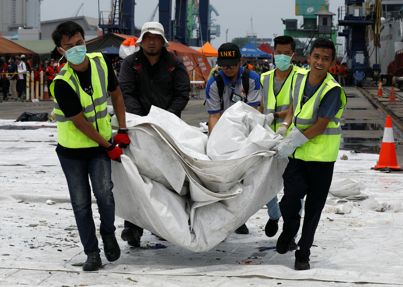 © Reuters. Rescue workers load up recovered debris of Lion Air flight JT610 onto a truck at Tanjung Priok port in Jakarta