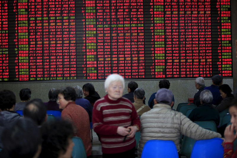 © Reuters. FILE PHOTO: Investors look at an electronic board showing stock information at a brokerage house in Shanghai