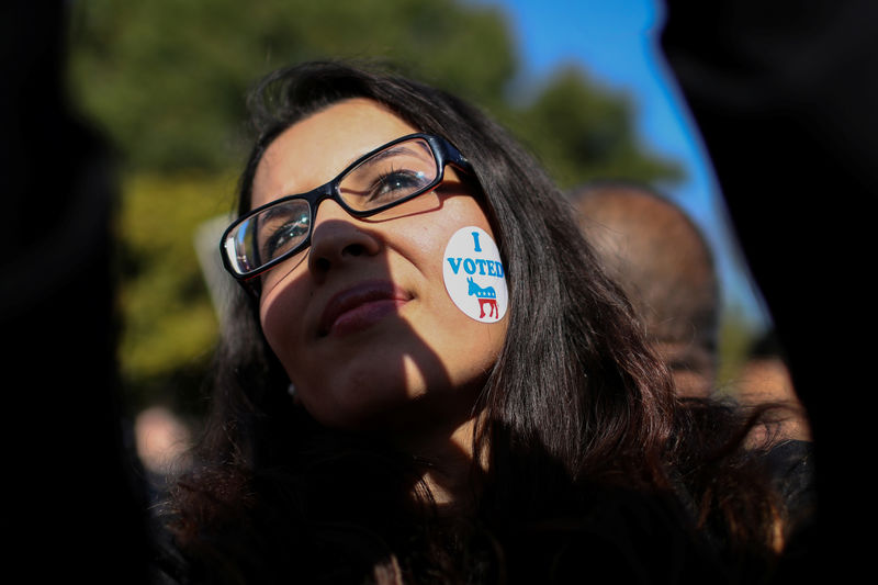 © Reuters. A woman wears a sticker on her face as she listens to U.S. Rep. Beto O'Rourke (D-TX) during the last day of early voting in Texas in Plano